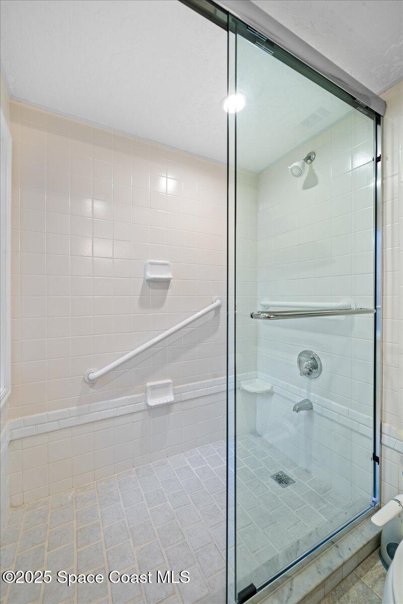 254 Seaview Street, Unit B Melbourne Beach, FL 32951 - Photo 57 of 77 a bathroom with a glass shower door