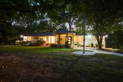 a front view of a house with yard patio and green space