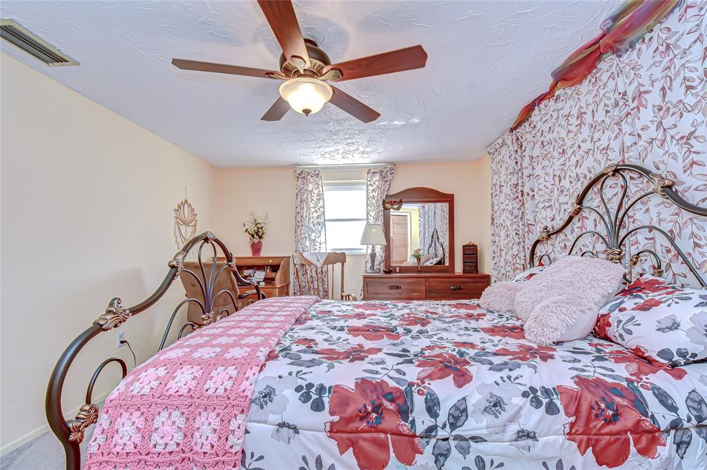 2128 Shannon Drive Holiday, FL 34690 - Photo 15 of 21 a bedroom with a large bed and a chandelier