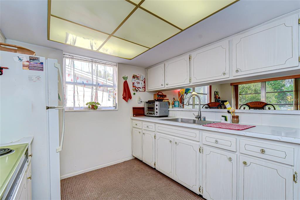 2128 Shannon Drive Holiday, FL 34690 - Photo 8 of 21 a kitchen with white cabinets and window