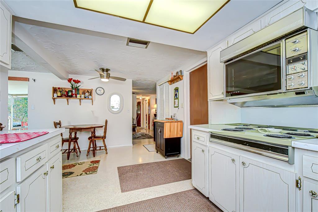 2128 Shannon Drive Holiday, FL 34690 - Photo 9 of 21 a kitchen with stainless steel appliances kitchen island granite countertop a sink dishwasher and cabinets with wooden floor