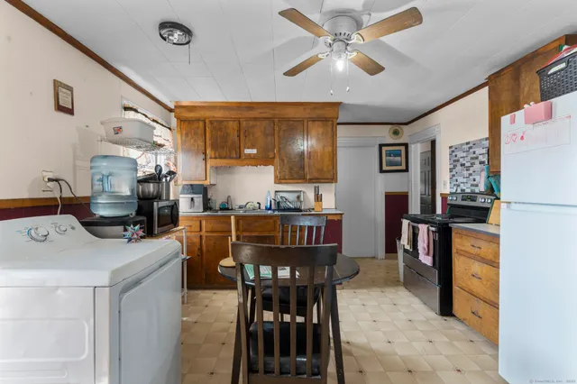 a dining hall with stainless steel appliances kitchen island granite countertop furniture and a dining table