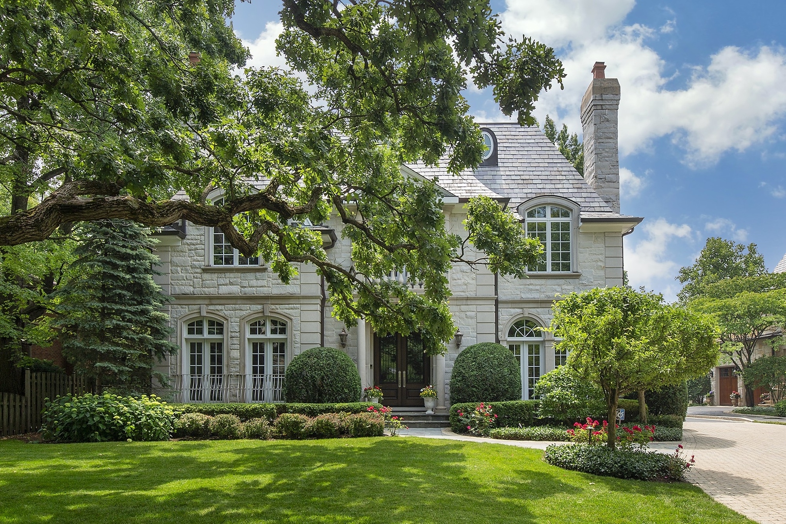 a front view of a house with a yard and trees