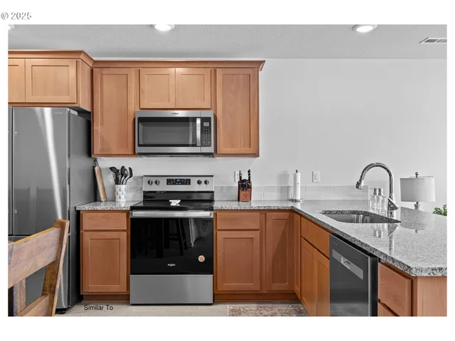 a kitchen with stainless steel appliances a stove a sink a microwave and cabinets