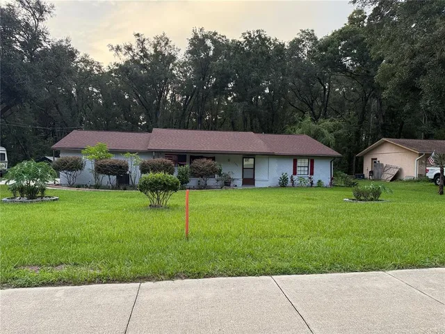 a view of a house with garden and a yard