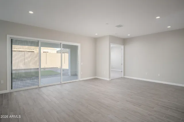 an empty room with wooden floor and sliding door
