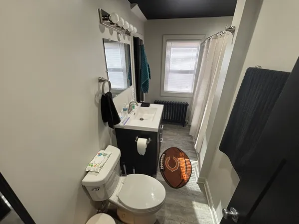a bathroom with a toilet a sink and a mirror