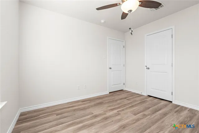an empty room with a window and wooden floor