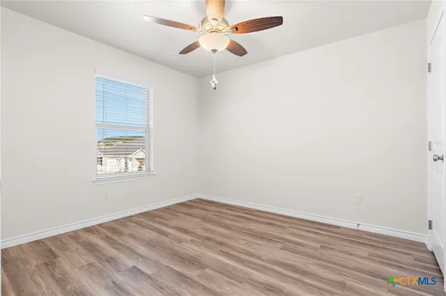 a view of room with wooden floor fan and window