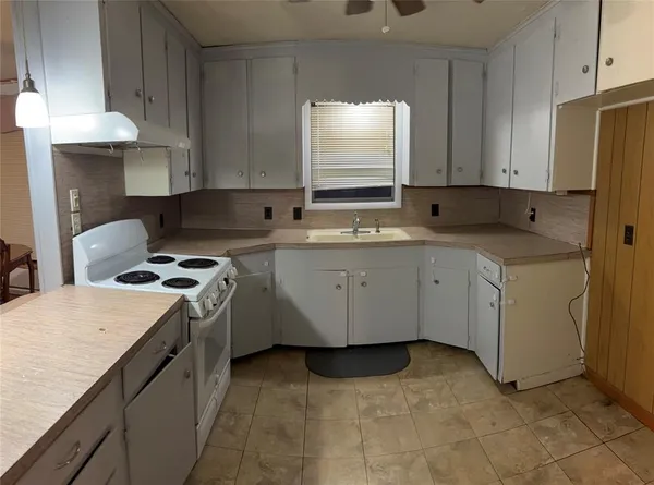 a kitchen with a stove sink and cabinets
