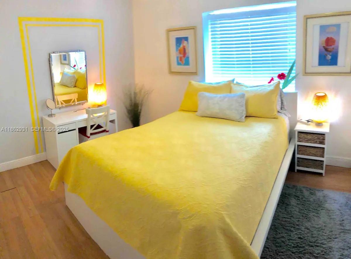 769 Northwest 10th Street Miami, FL 33136 - Photo 16 of 25 a bed sitting in a bedroom next to a window