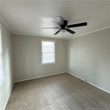 an empty room with a ceiling fan and window