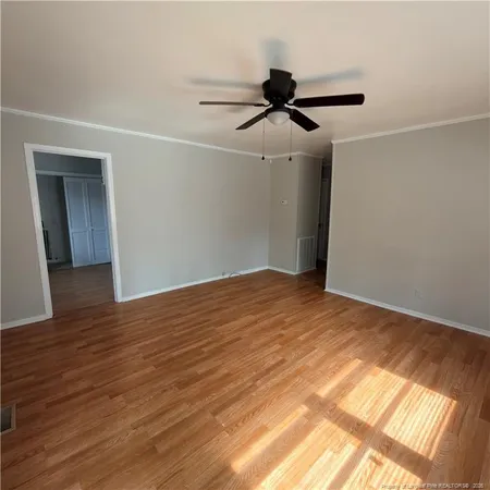 a view of empty room with wooden floor