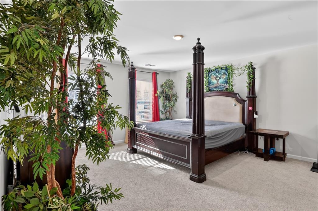 930 Sly Fox Run Fairburn, GA 30213 - Photo 14 of 28 a bed room with a bed and potted plant