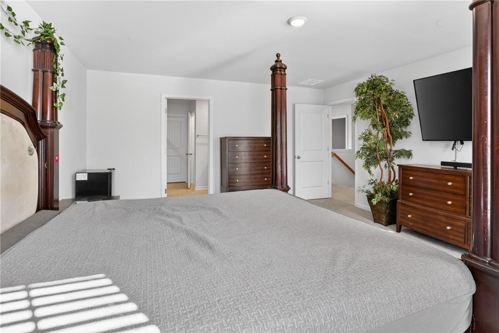 930 Sly Fox Run Fairburn, GA 30213 - Photo 16 of 28 a bedroom with a bed and a flat tv screen on dresser