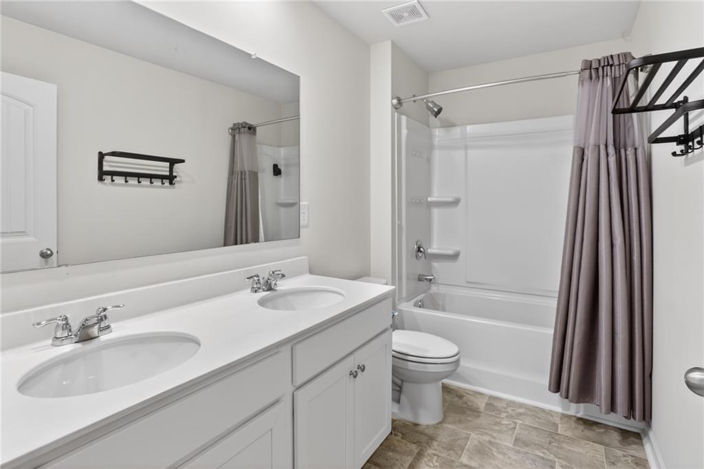 930 Sly Fox Run Fairburn, GA 30213 - Photo 19 of 28 a bathroom with a sink a toilet and shower