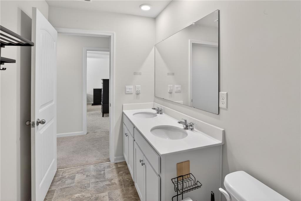 930 Sly Fox Run Fairburn, GA 30213 - Photo 20 of 28 a spacious bathroom with a sink a toilet and a mirror