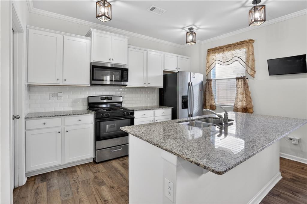 930 Sly Fox Run Fairburn, GA 30213 - Photo 8 of 28 a kitchen with stainless steel appliances granite countertop a sink refrigerator and microwave