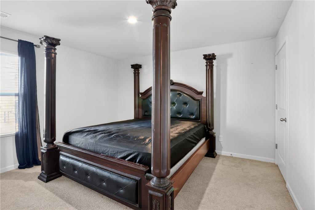 930 Sly Fox Run Fairburn, GA 30213 - Photo 10 of 28 a bedroom with a bed and a chandelier