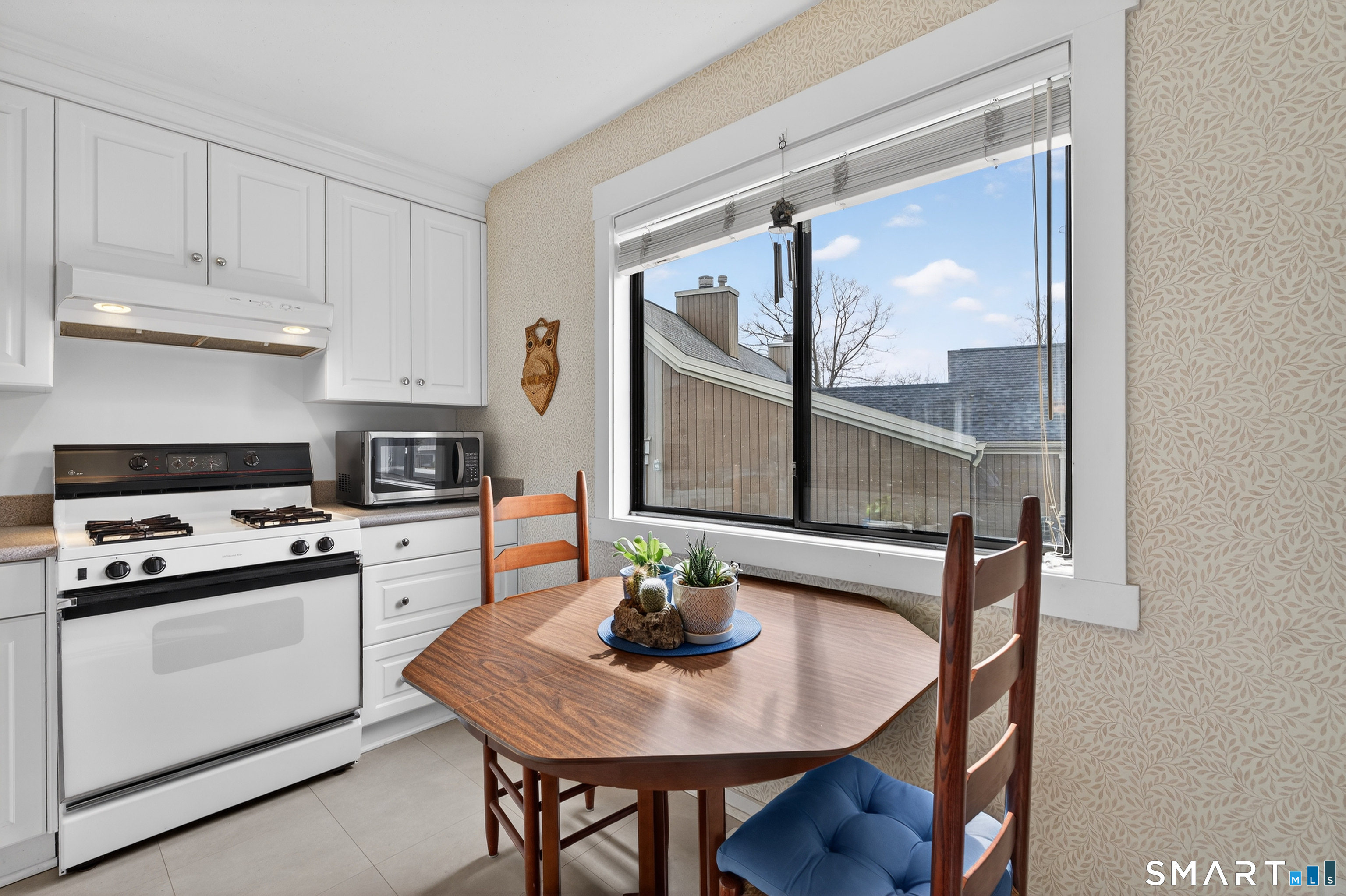 196 Apache Lane, Unit A Stratford, CT 06614 - Photo 5 of 40 a kitchen with stainless steel appliances a table chairs and a refrigerator