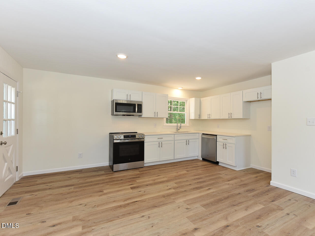 939 Cheves Road Zebulon, NC 27597 - Photo 5 of 21 a large kitchen with stainless steel appliances granite countertop a stove a sink dishwasher and a refrigerator with wooden floor