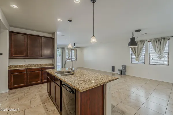 a kitchen with stainless steel appliances granite countertop a sink a stove and a wooden floors