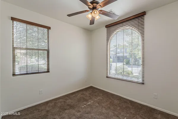an empty room with closet and a chandelier fan