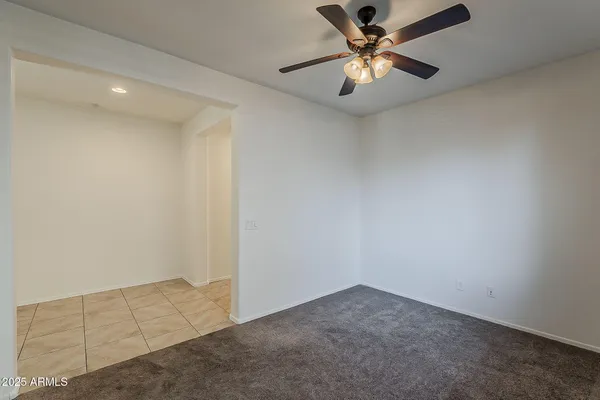 an empty room with a ceiling fan and a fan