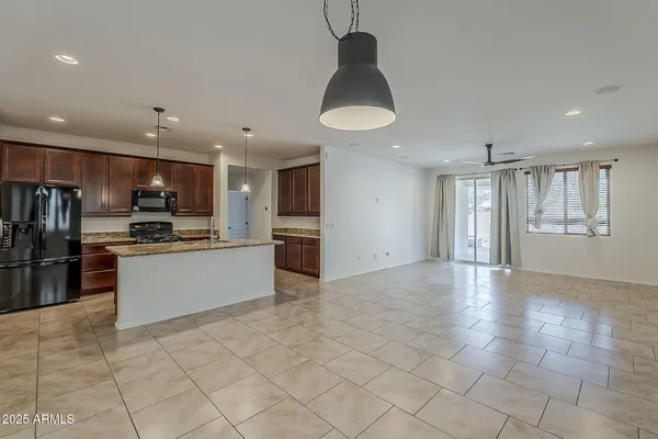 a large kitchen with stainless steel appliances kitchen island granite countertop a refrigerator oven a sink and dishwasher