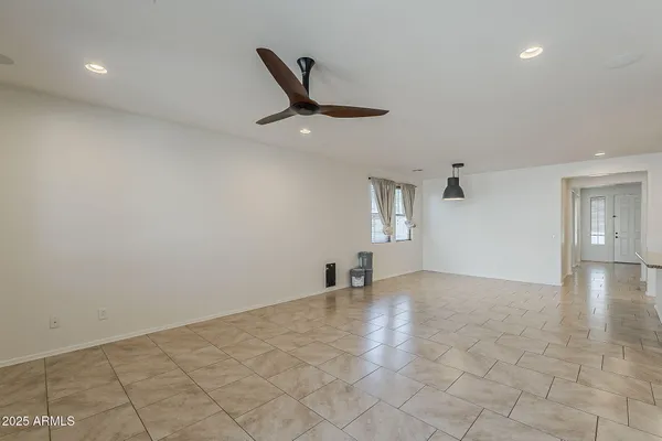 an empty room with windows and ceiling fan