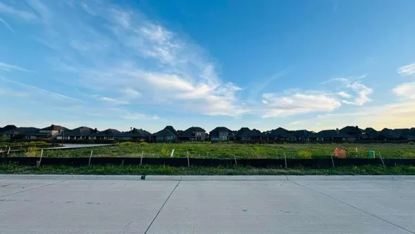 a view of a garden with houses in the back