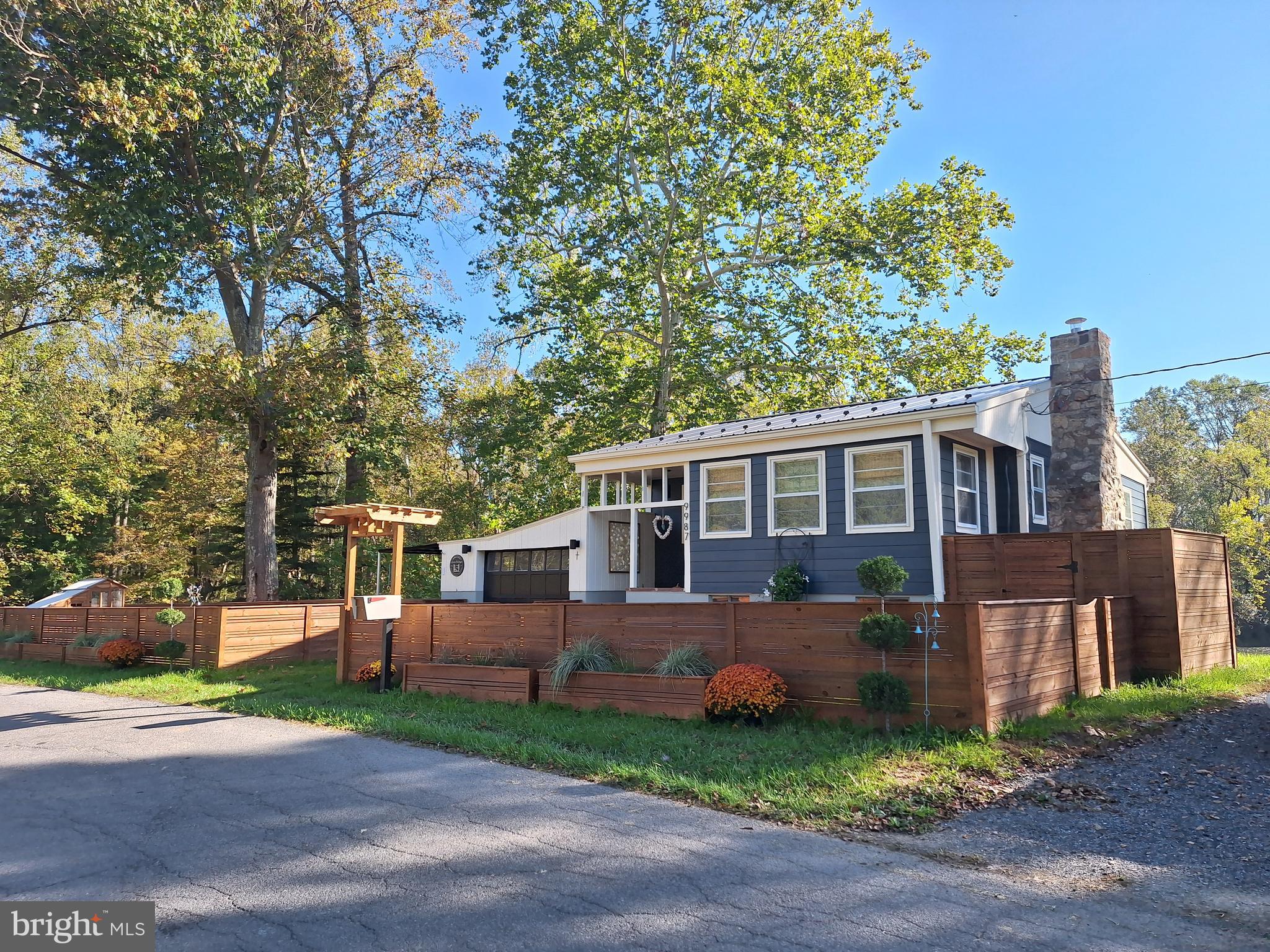 9987 Capon River Road Yellow Spring, WV 26865 - Photo 2 of 42 a front view of a house with a garden