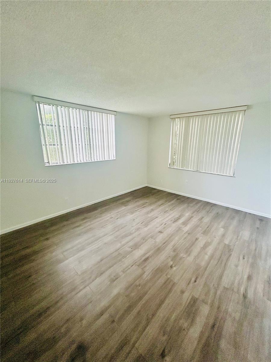 3100 West Rolling Hills Circle, Unit 310 Davie, FL 33328 - Photo 16 of 39 a view of an empty room with wooden floor and a window