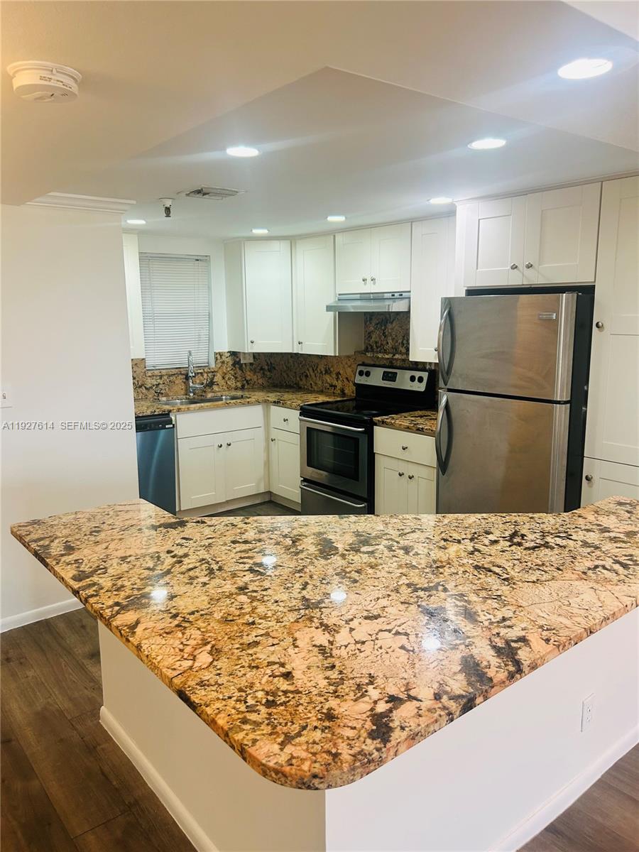 3100 West Rolling Hills Circle, Unit 310 Davie, FL 33328 - Photo 2 of 39 a kitchen with a stove top oven and refrigerator
