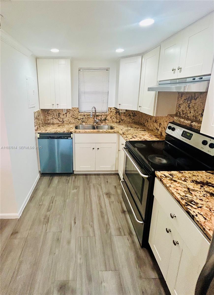 3100 West Rolling Hills Circle, Unit 310 Davie, FL 33328 - Photo 5 of 39 a kitchen with granite countertop a stove and cabinets