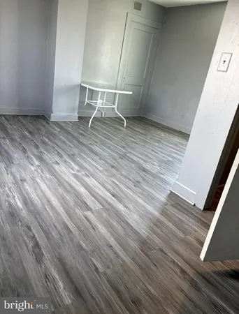 a view of an empty room with wooden floor and stairs