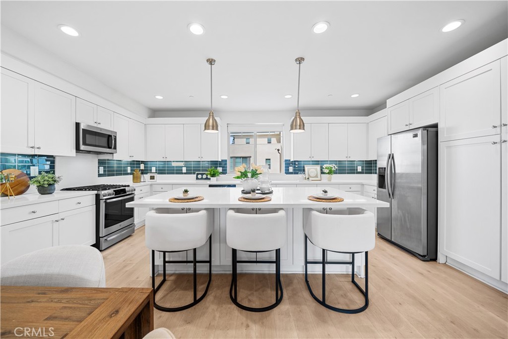115 Episode Irvine, CA 92618 - Photo 15 of 43 a kitchen with a table chairs refrigerator and microwave