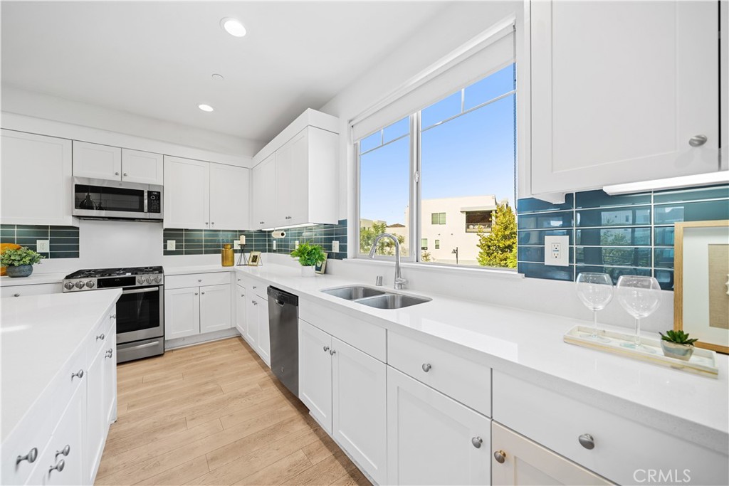 115 Episode Irvine, CA 92618 - Photo 16 of 43 a kitchen with granite countertop a sink stainless steel appliances and white cabinets