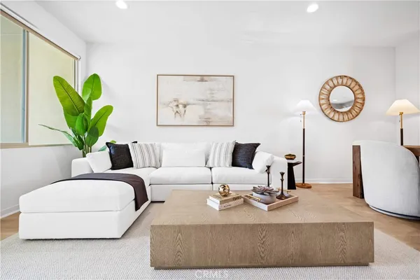 a living room with furniture a clock and a potted plant