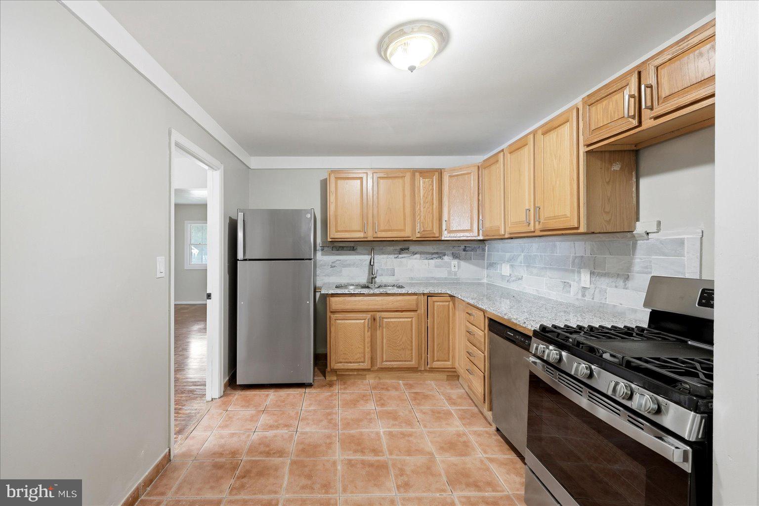9110 Meadow Heights Road Randallstown, MD 21133 - Photo 13 of 39 Modern kitchen with warm wood tones.