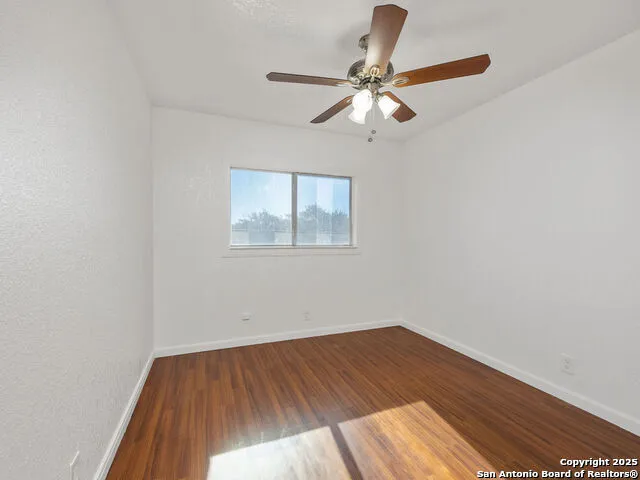 a view of a room with wooden floor and fan