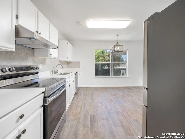 a kitchen with a stove a sink and a window
