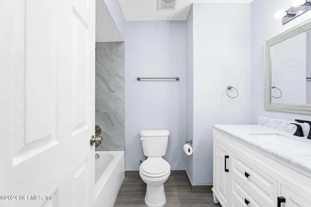a bathroom with a sink toilet vanity and bathtub