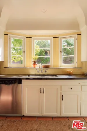 a kitchen with granite countertop white cabinets and a large window