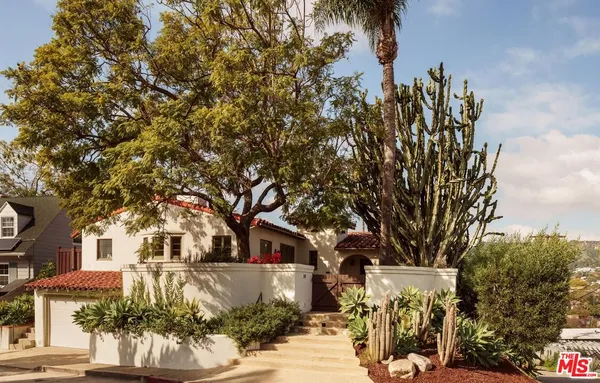 a front view of a house with a tree