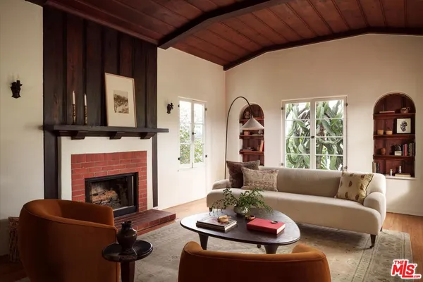 a living room with furniture fireplace and a large window
