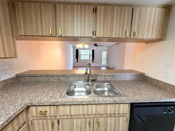 a kitchen with granite countertop a sink a stove and cabinets