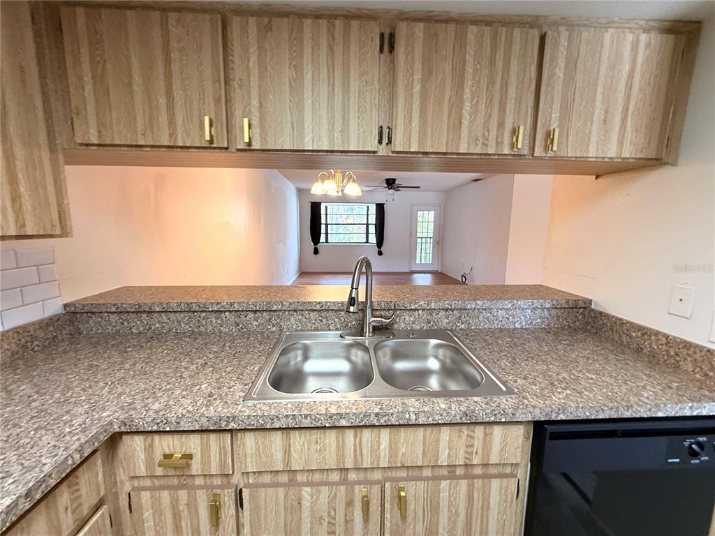 12155 Environmental Drive, Unit 6 New Port Richey, FL 34654 - Photo 12 of 42 a kitchen with granite countertop a sink a stove and cabinets