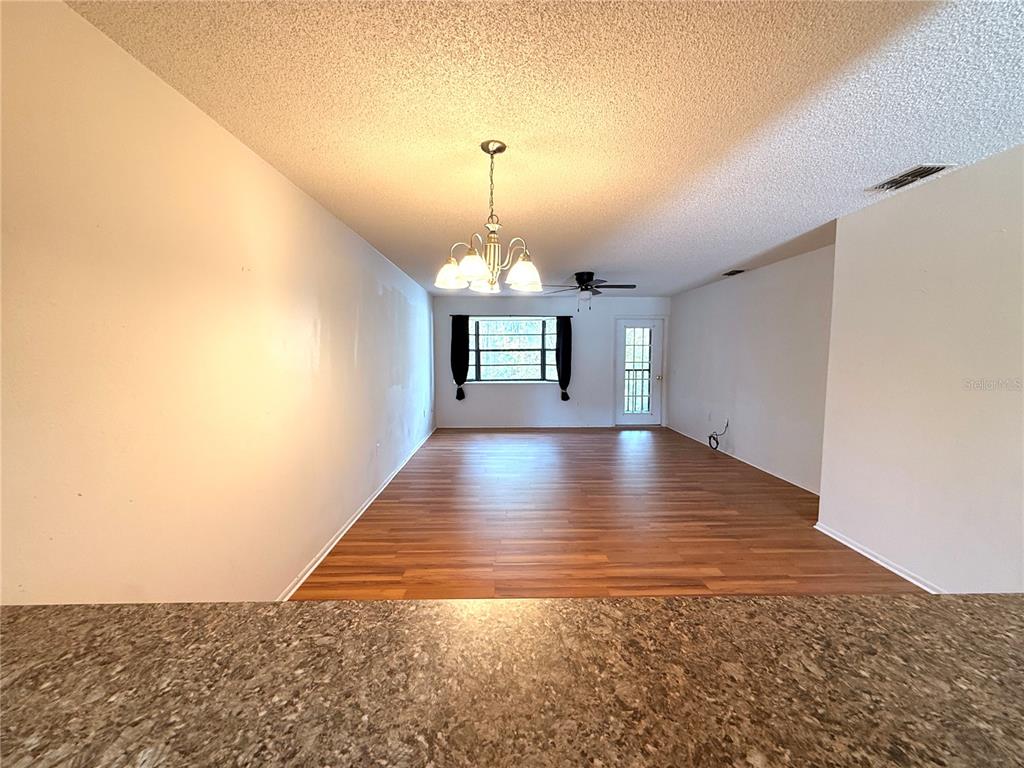 12155 Environmental Drive, Unit 6 New Port Richey, FL 34654 - Photo 13 of 42 a view of empty room with wooden floor and fan