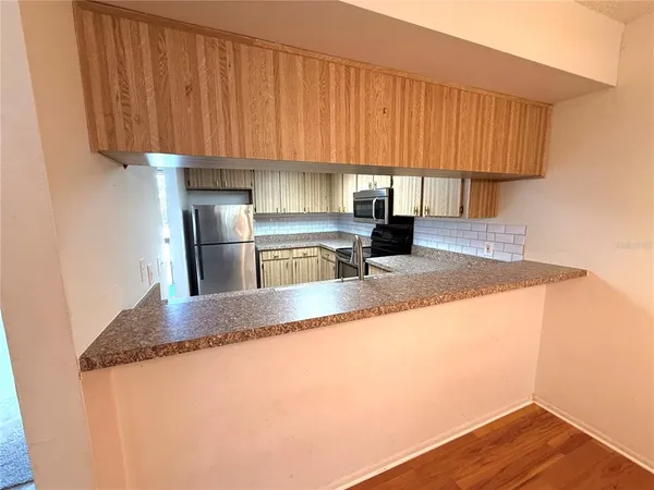 a kitchen with granite countertop wooden cabinets a refrigerator and a sink